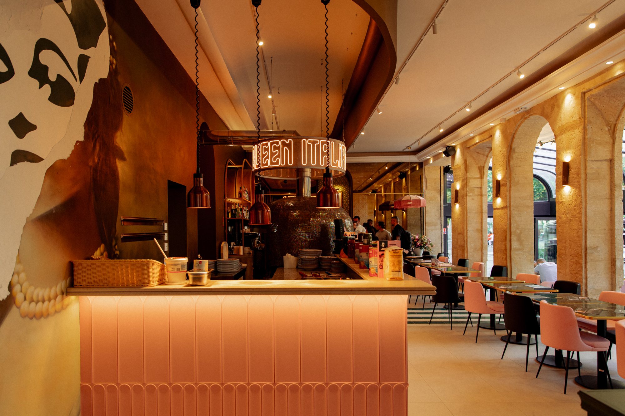 Italian Queen, Avignon, comptoir rose, anneau néon au-dessus du four en mosaïque et arcades en pierre