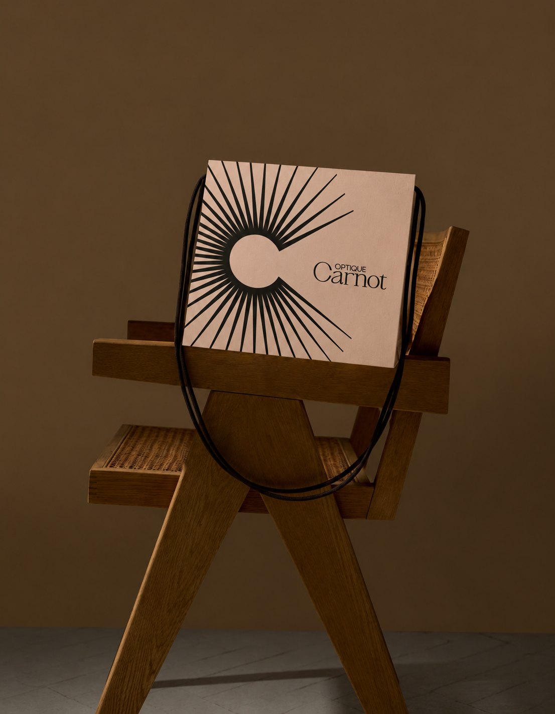 Optique Carnot – shopping bag printed with the black sun rays and logotype, packaging by Jon Filin